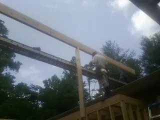 Carpenter setting a ridge beam over a new addition frame — Ice Dam Removal by Roofing Brothers in Deforest